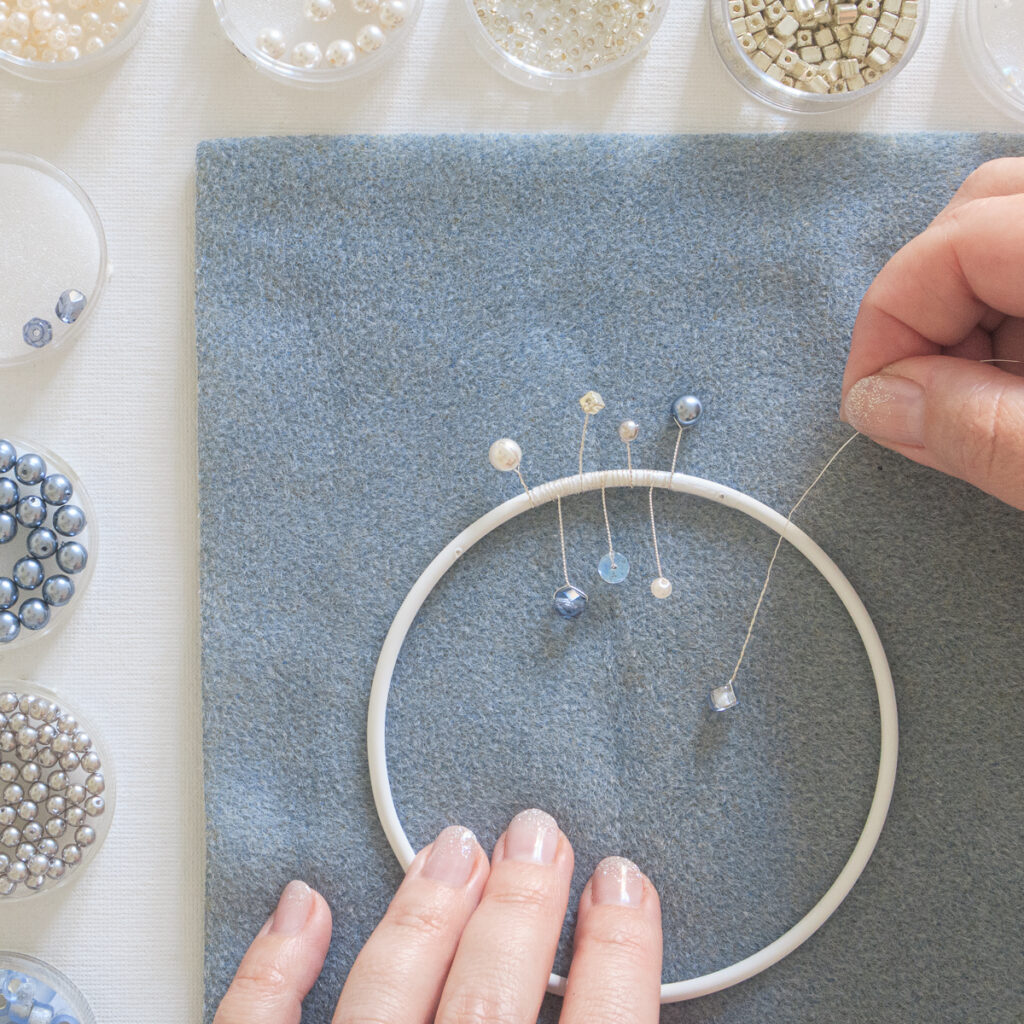 Lichtfänger basteln: Mit weiteren Drahtstücken und Perlen den ganzen Drahtring umwickeln